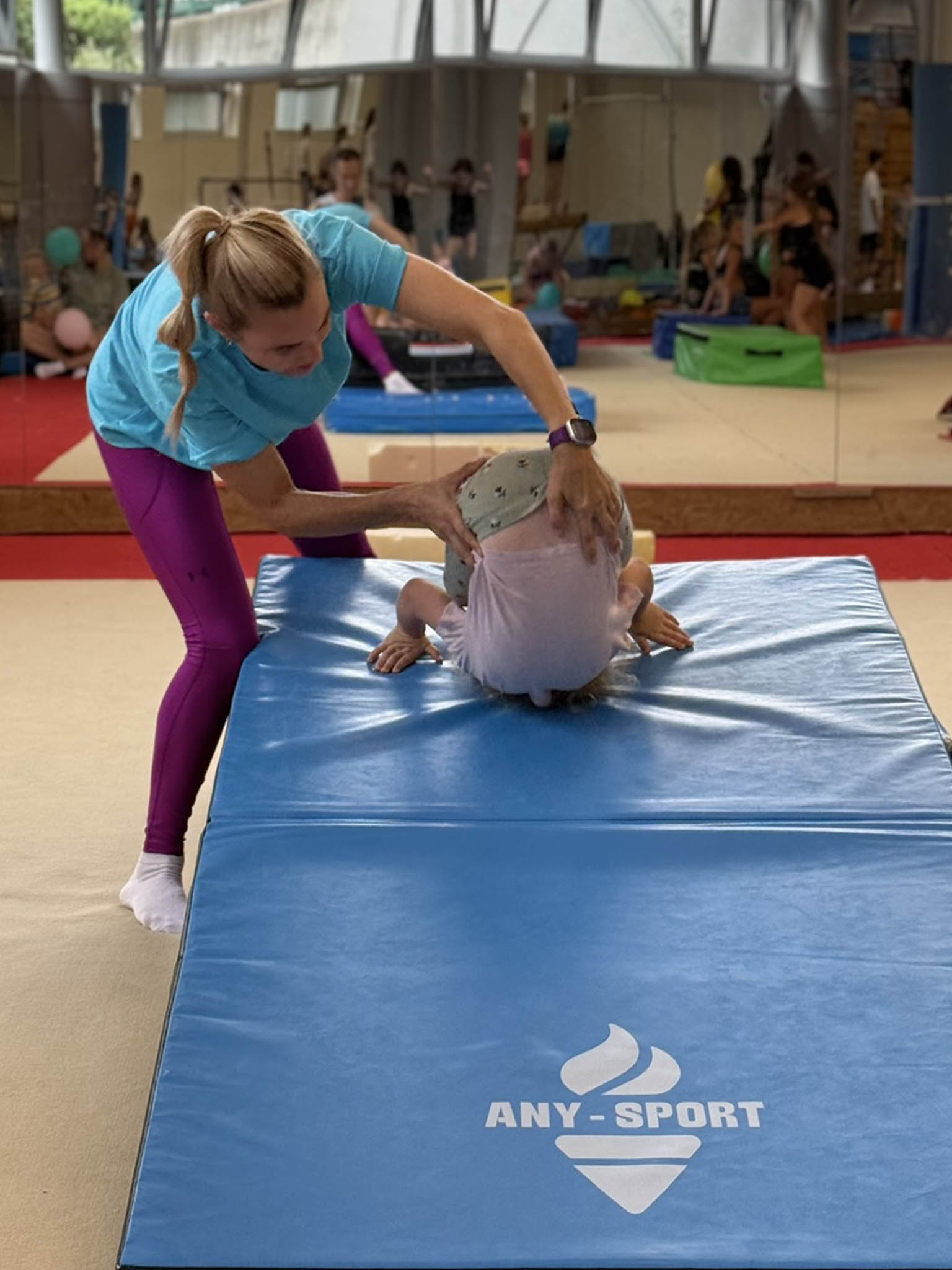 Dítě skáče na trampolíně za podpory trenérky